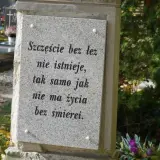 Kamienna płyta na grobie ziemnym z napisem: "Szczęście bez łez nie istnieje, tak samo jak nie ma życia bez śmierci.