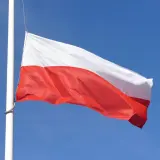 Biało-czerwona flaga Polski powiewa na maszcie na tle błękitnego nieba. Czy żałoba jest obowiązkowa?