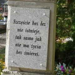 Kamienna płyta na grobie ziemnym z napisem: "Szczęście bez łez nie istnieje, tak samo jak nie ma życia bez śmierci.