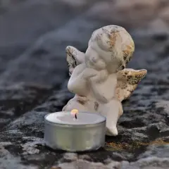 Aniołek czuwa przy płonącej świecy, symbolizując żałobę po cioci.