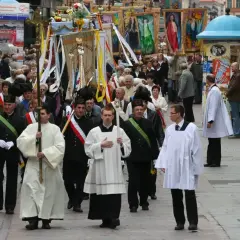 Procesja religijna z chorągwiami i duchownymi w strojach. Długość mszy świętej może być różna, ale ta uroczystość trwa.