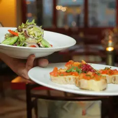 Lekki poczęstunek po pogrzebie: świeża sałatka i bruschetta z pomidorami.