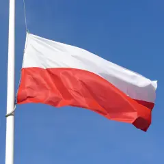 Biało-czerwona flaga Polski powiewa na maszcie na tle błękitnego nieba. Czy żałoba jest obowiązkowa?