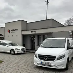Przed budynkiem "JARPOL-KAM" stoją karawan i van. Firma zajmuje się transportem zmarłych, odpowiadając na pytanie, kto pokrywa koszty sprowadzenia zwłok z zagranicy.