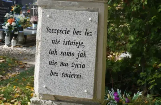 Kamienna płyta na grobie ziemnym z napisem: "Szczęście bez łez nie istnieje, tak samo jak nie ma życia bez śmierci.