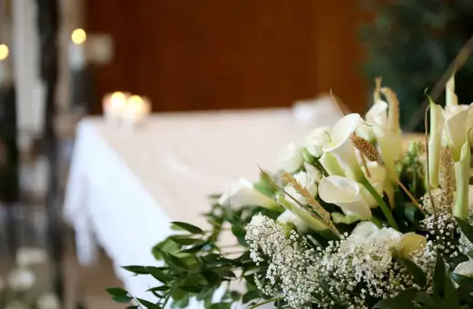 Białe lilie i róże na pogrzebie. Choć katolik na pogrzebie świadka jehowy, wszyscy łączą się w smutku.