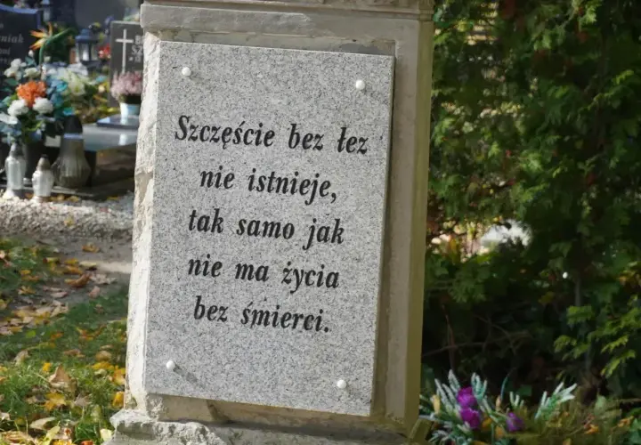 Kamienna płyta na grobie ziemnym z napisem: "Szczęście bez łez nie istnieje, tak samo jak nie ma życia bez śmierci.
