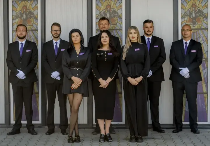 Zespół w czarnych strojach przed witrażem. Jeśli chcesz dowiedzieć się, jak sprawdzić datę pogrzebu, skontaktuj się z nimi.