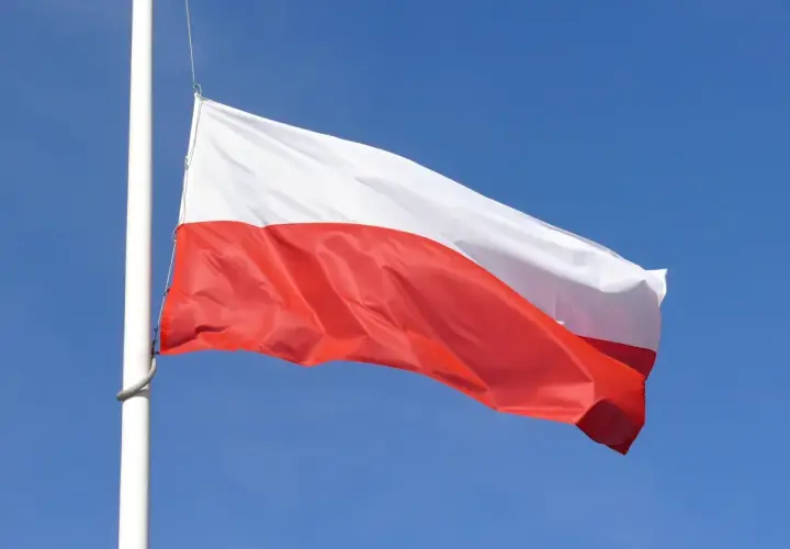 Biało-czerwona flaga Polski powiewa na maszcie na tle błękitnego nieba. Czy żałoba jest obowiązkowa?