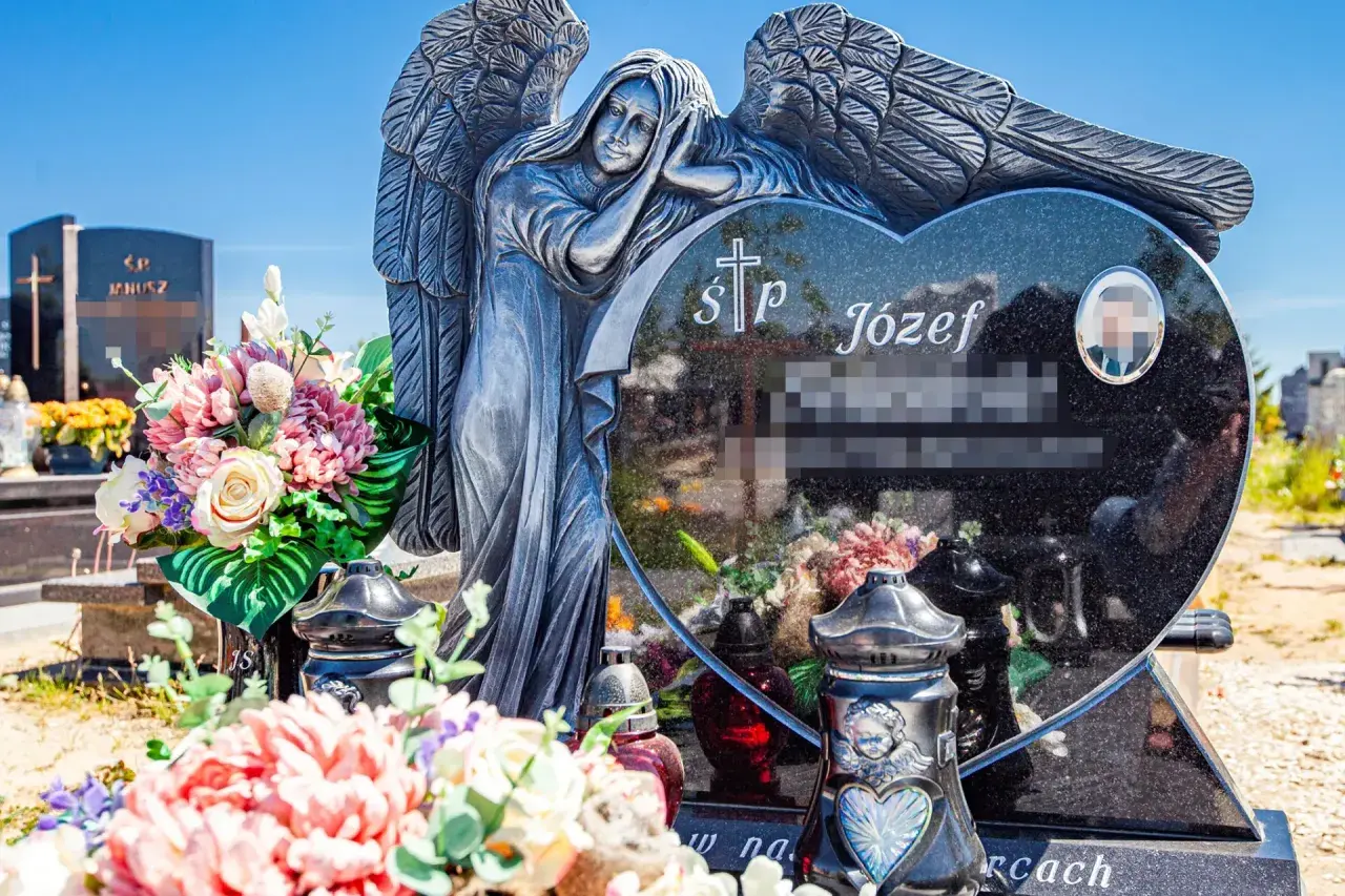 Kamienna anielica czuwa nad sercem z granitu, na którym widnieją krótkie sentencje na pomnik. Kwiaty i znicze zdobią grób.