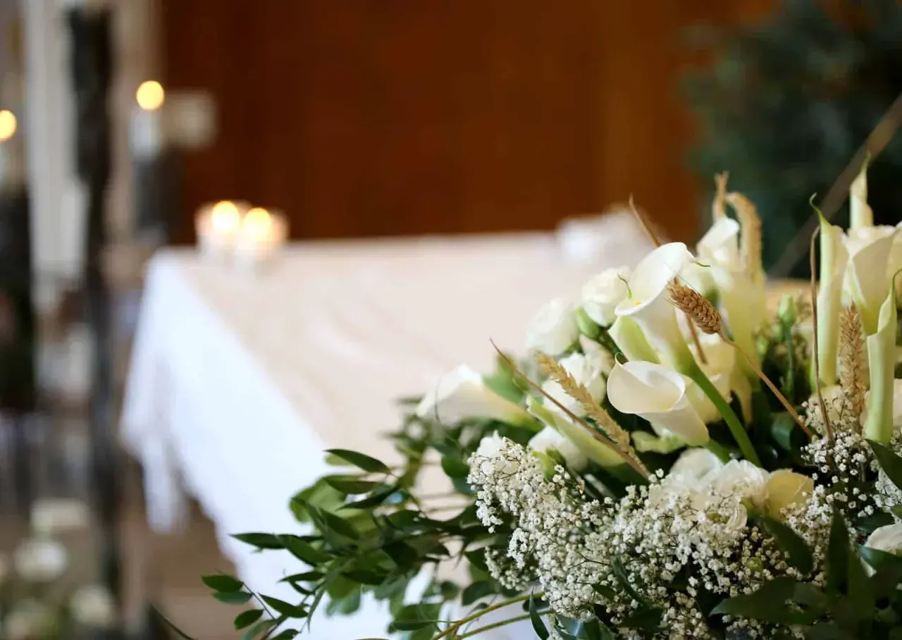 Białe lilie i róże na pogrzebie. Choć katolik na pogrzebie świadka jehowy, wszyscy łączą się w smutku.