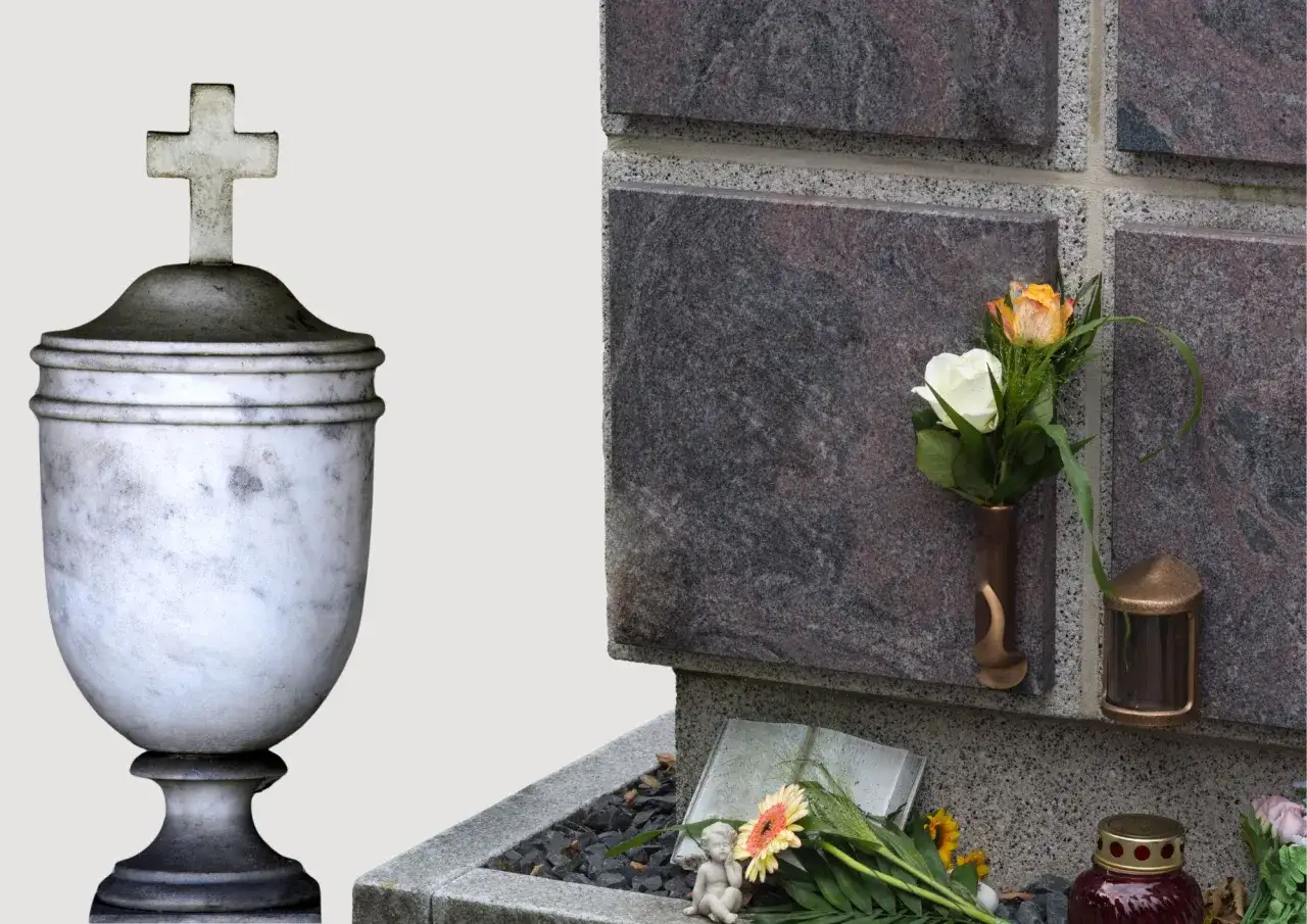 Kamienna urna z krzyżem i wazon z kwiatami na nagrobku. W tle płyty nagrobne, a u dołu książka i znicz. Prochy spoczywają w tym miejscu.