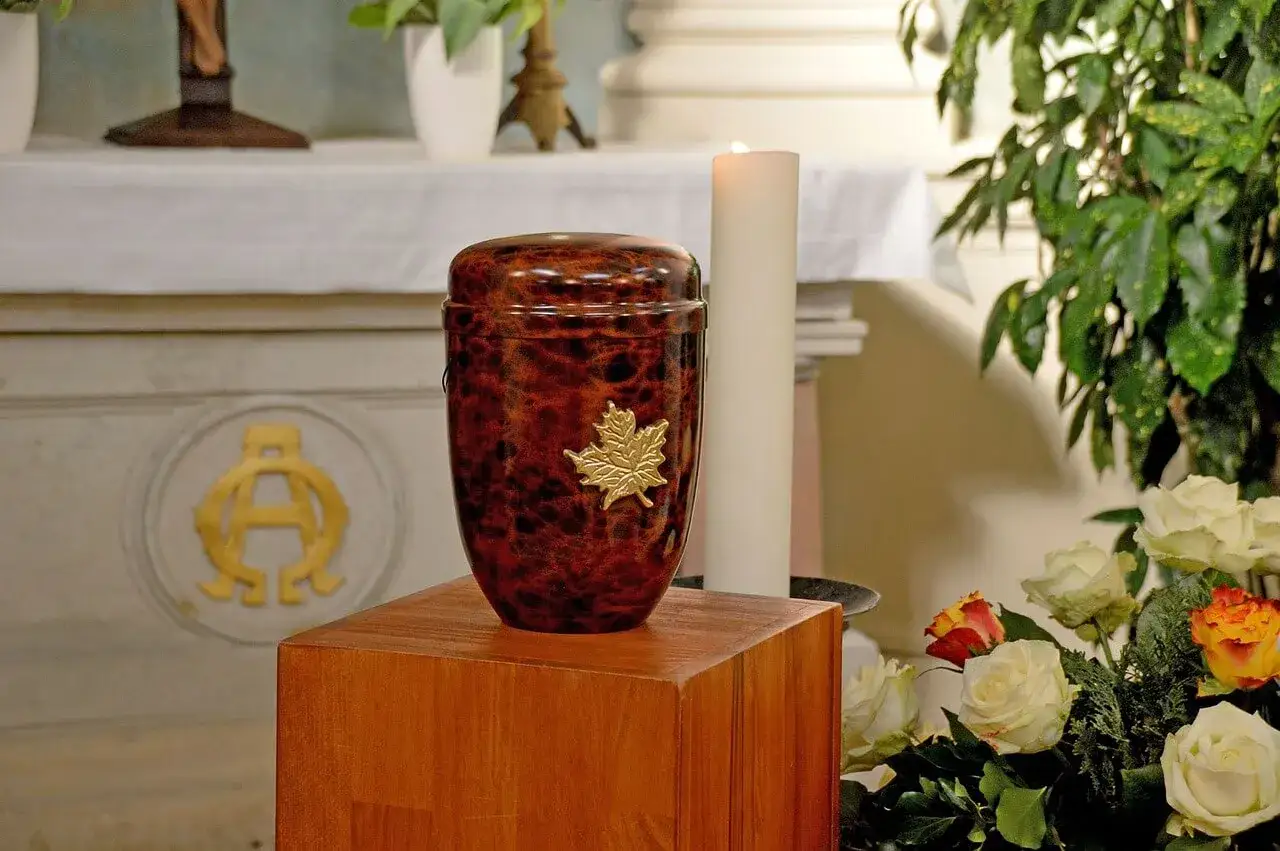 Elegancka, brązowa urna z liściem klonu, symbolizująca spokój i pamięć. To miejsce wiecznego spoczynku.